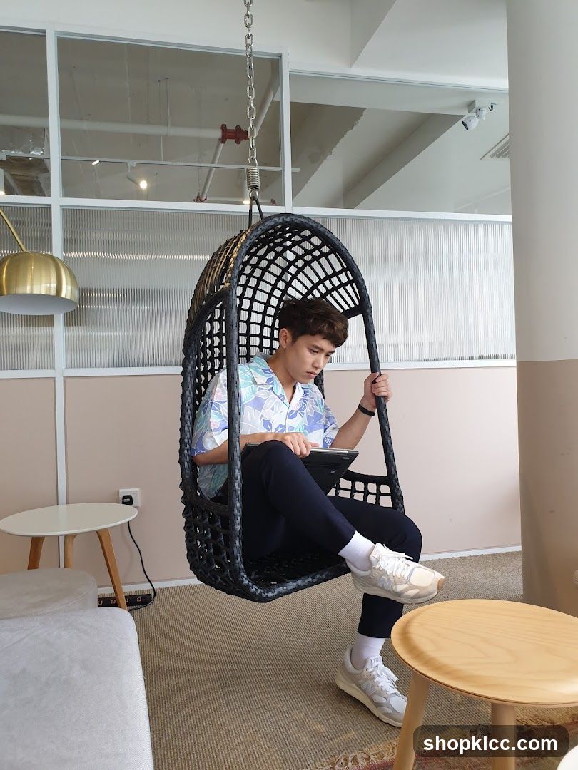 Man in Hanging Chair with Tablet