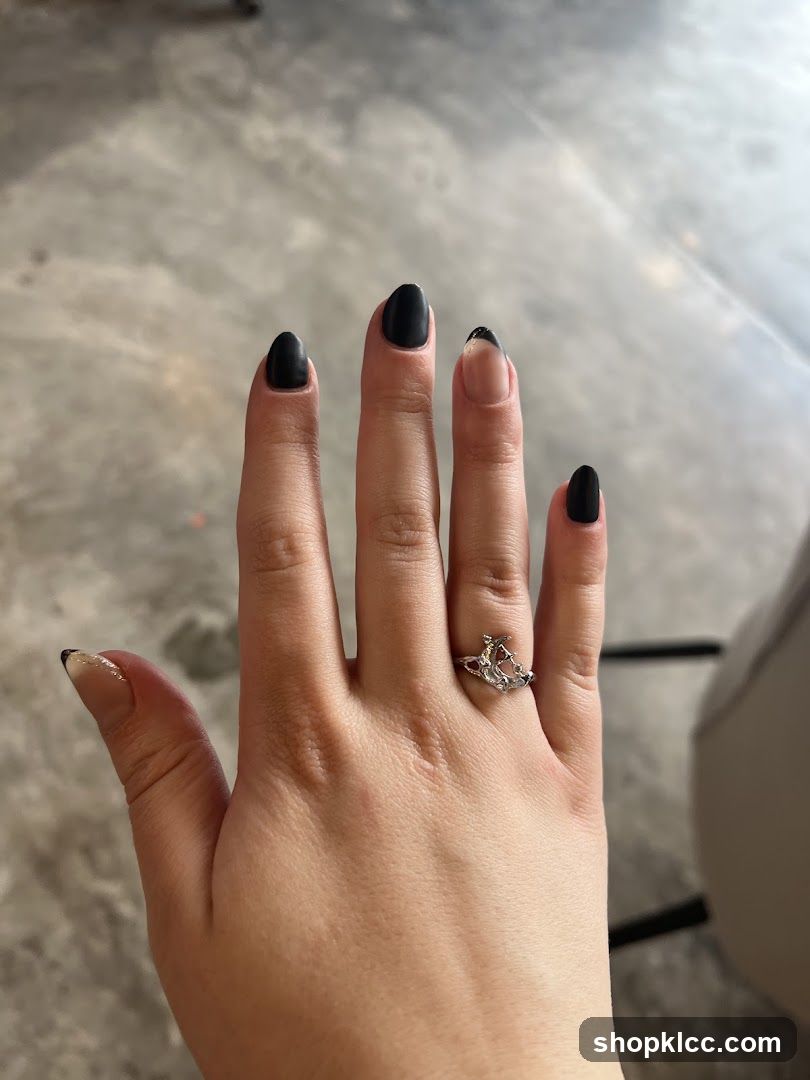 Hand with black nails and ring