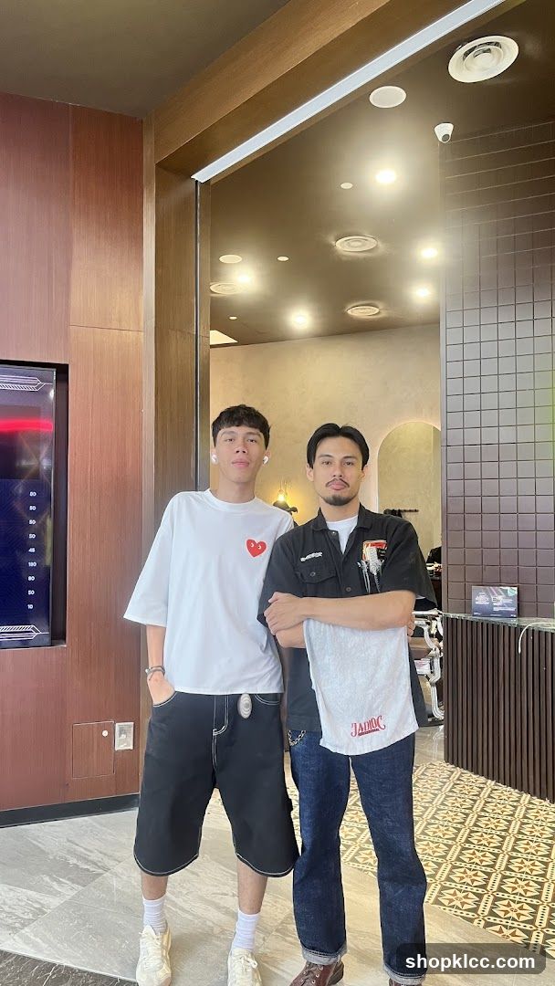 Two men posing in a barbershop