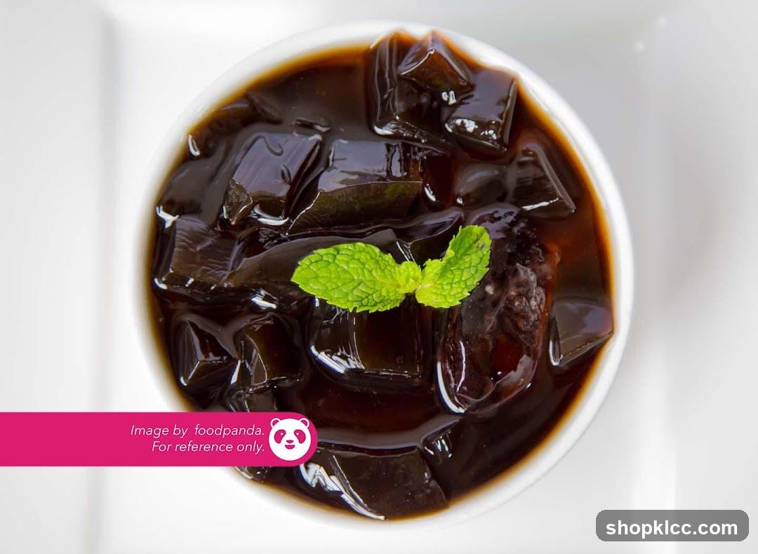 Bowl of black jelly dessert with mint garnish