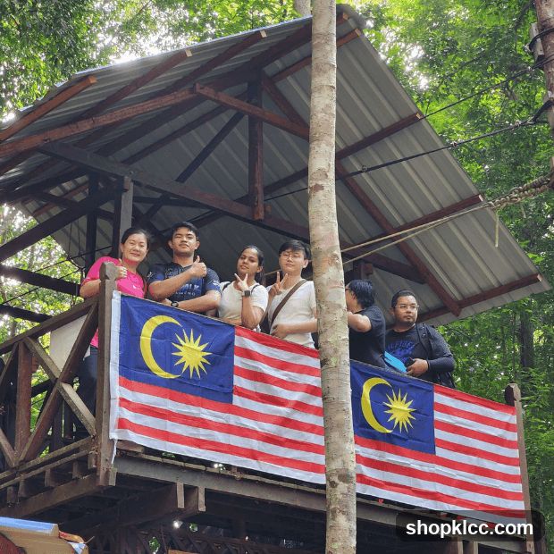 Group on a wooden platform with Malaysian flags
