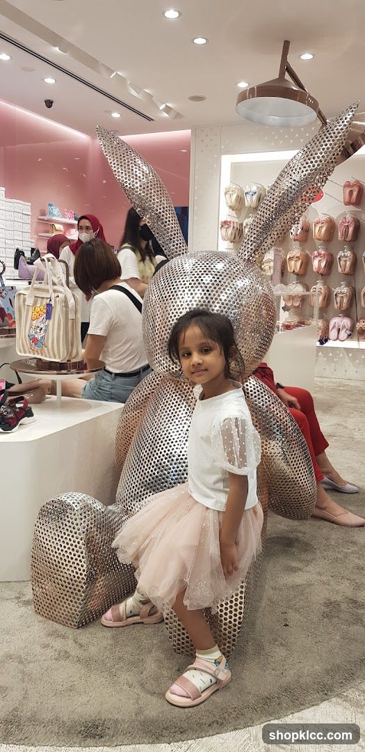 Girl Poses Next to a Large Bunny Sculpture