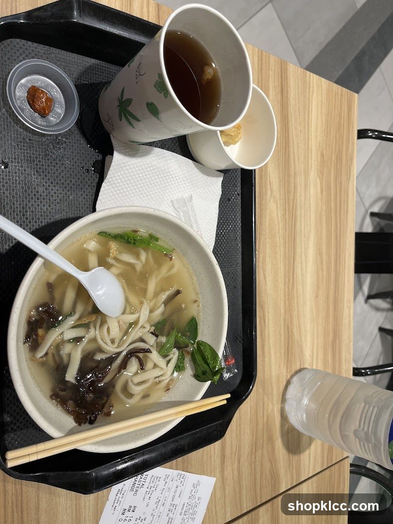 Bowl of noodles with soup and drink on a tray