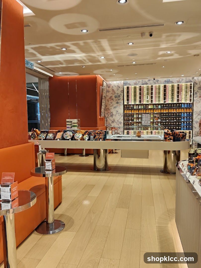Interior of a well-lit store with orange seating and display cases.