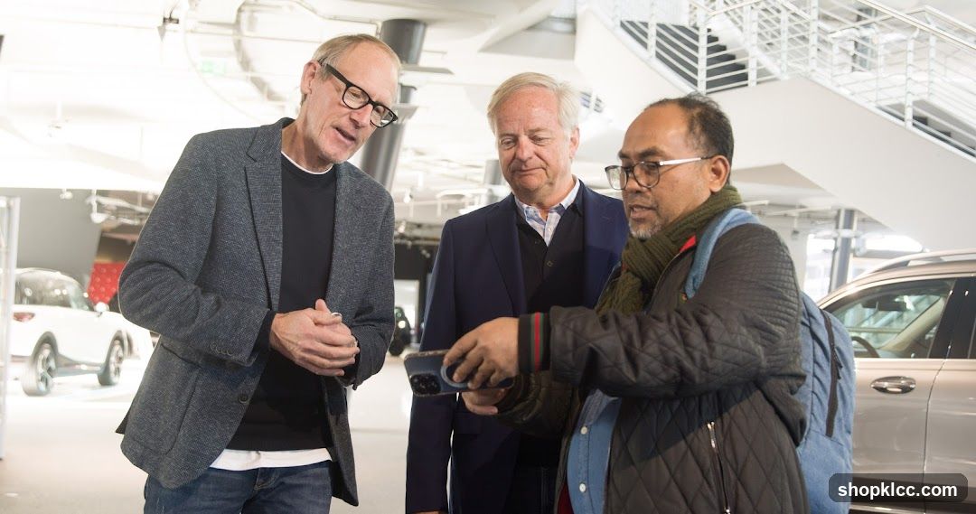 Three men in a car showroom