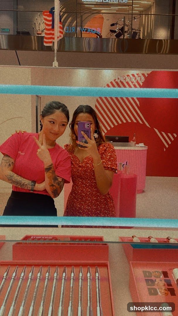 Two women taking a mirror selfie in a store
