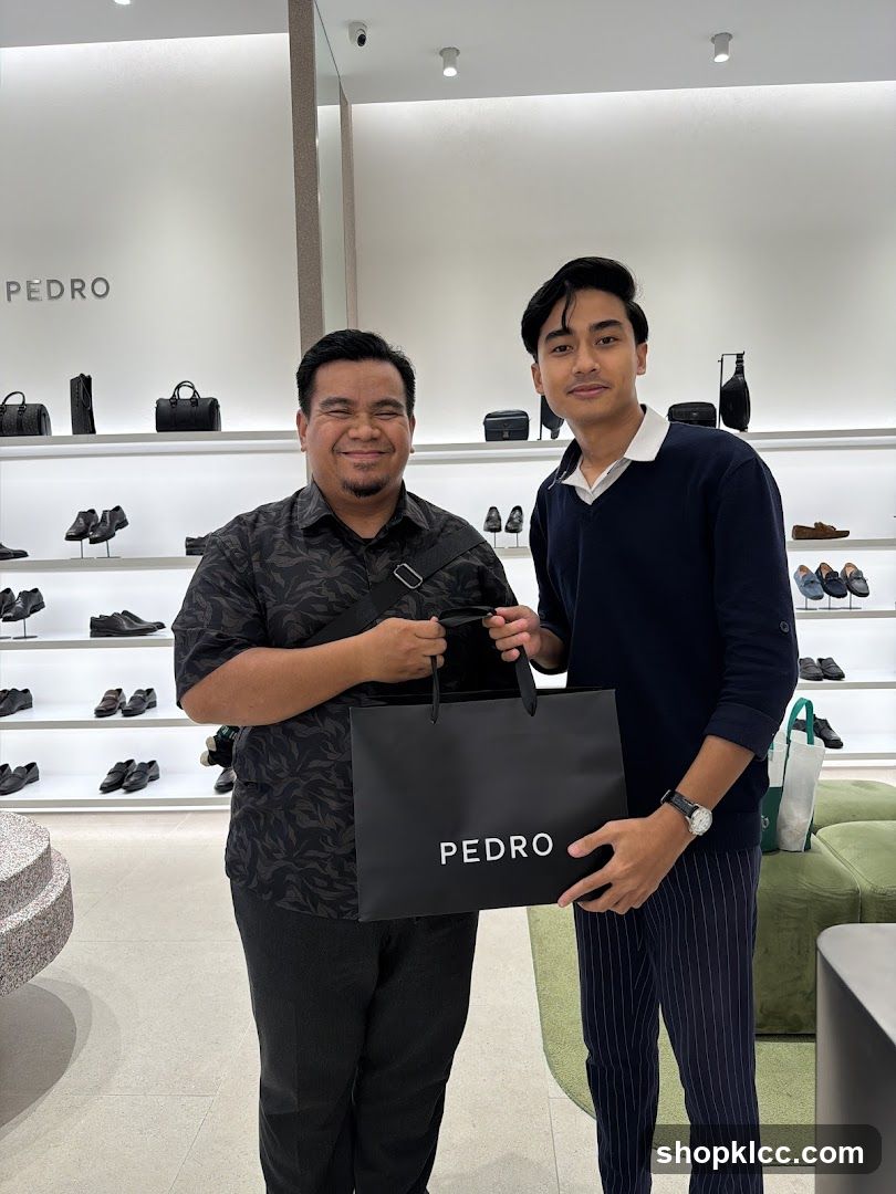 Two men holding a Pedro shopping bag in a store
