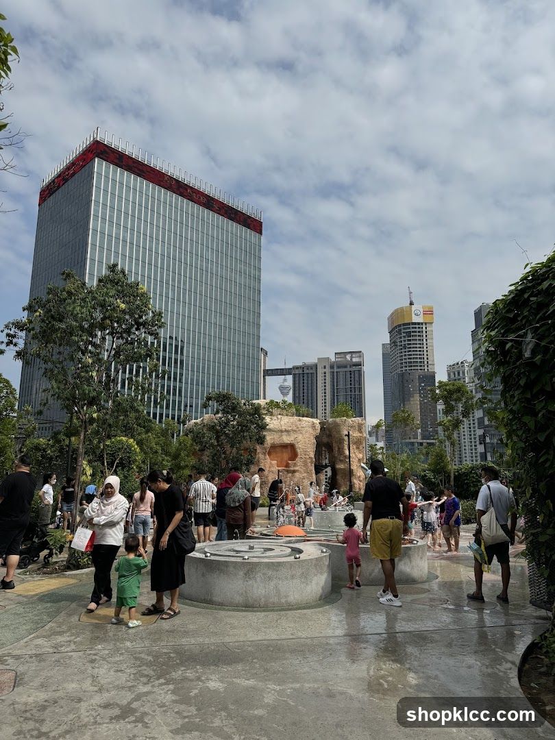 People Enjoying a Water Play Area in a City Park