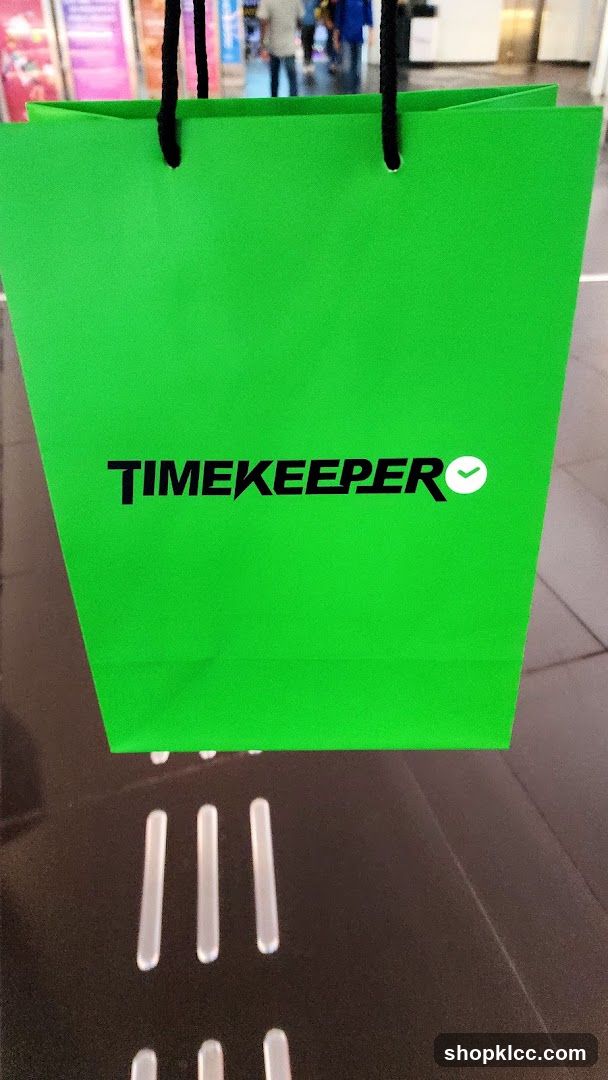 Green shopping bag with "TIMEKEEPER" logo