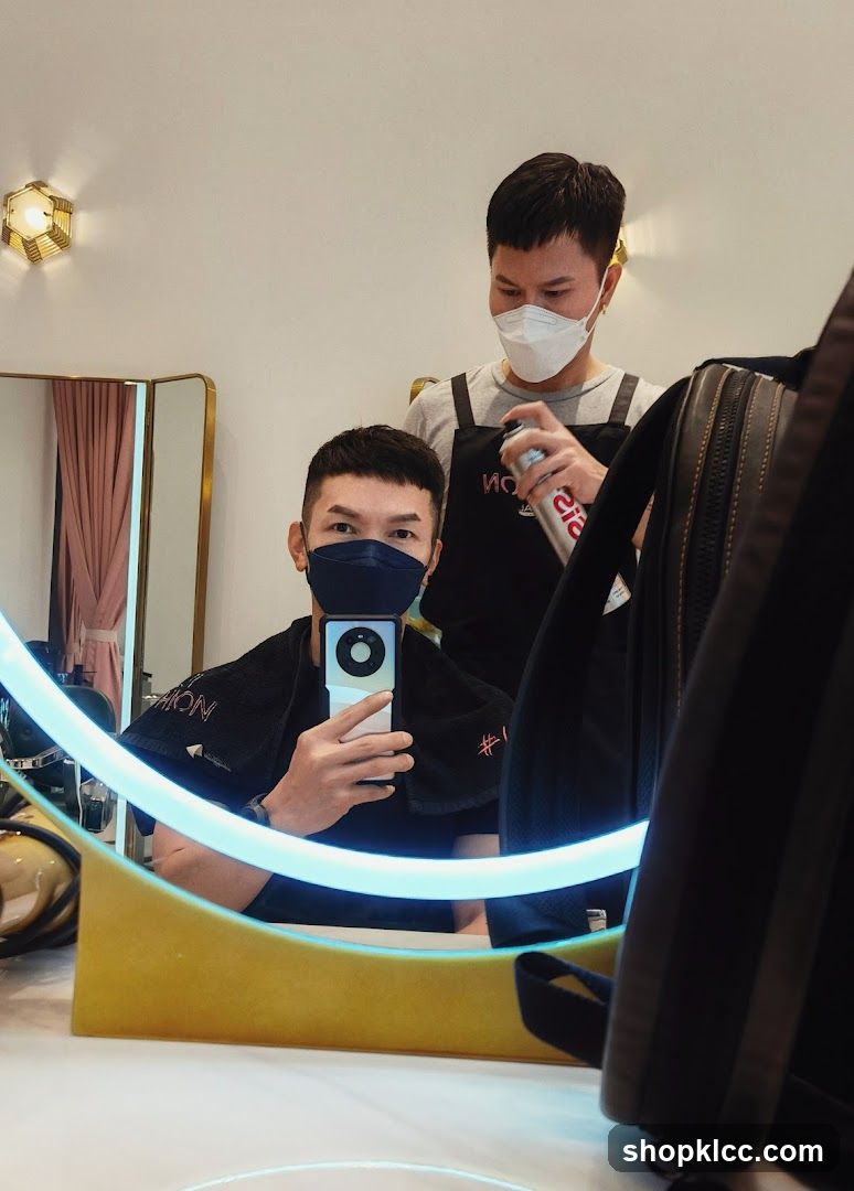 Hairdresser spraying hairspray on client
