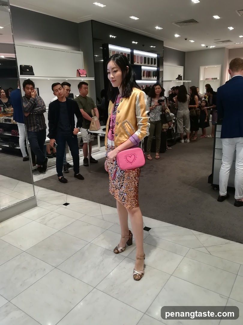 Woman in a sparkly dress and bomber jacket in a store