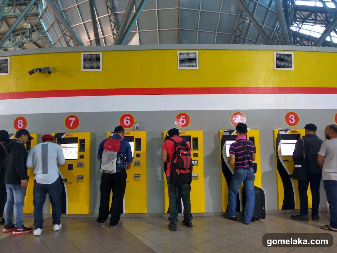 People at ticket kiosks in a transit station