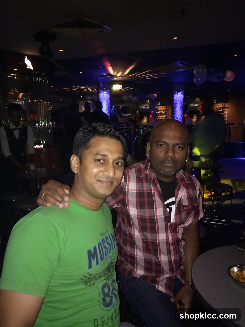 Two men posing in a dimly lit bar