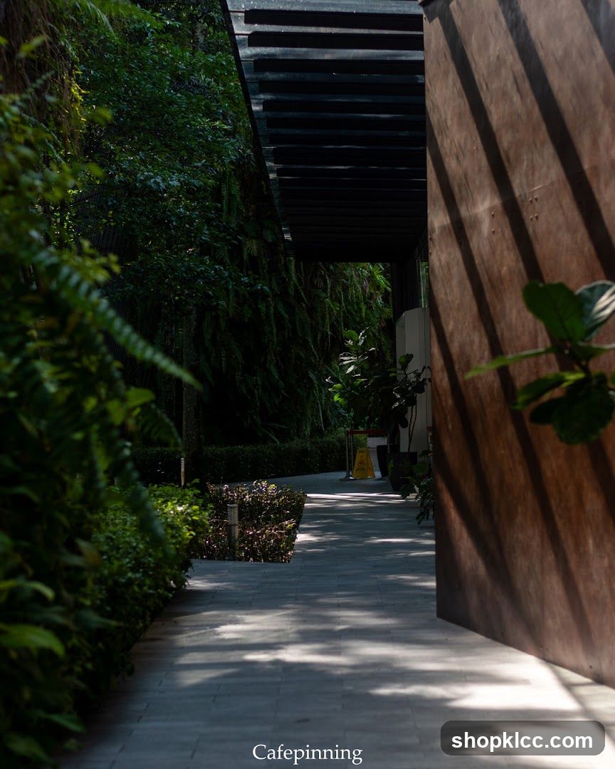 Pathway to a building entrance with lush greenery