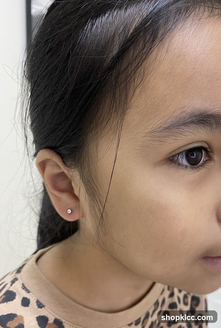 Close-up of a young girl's ear with a small stud earring.