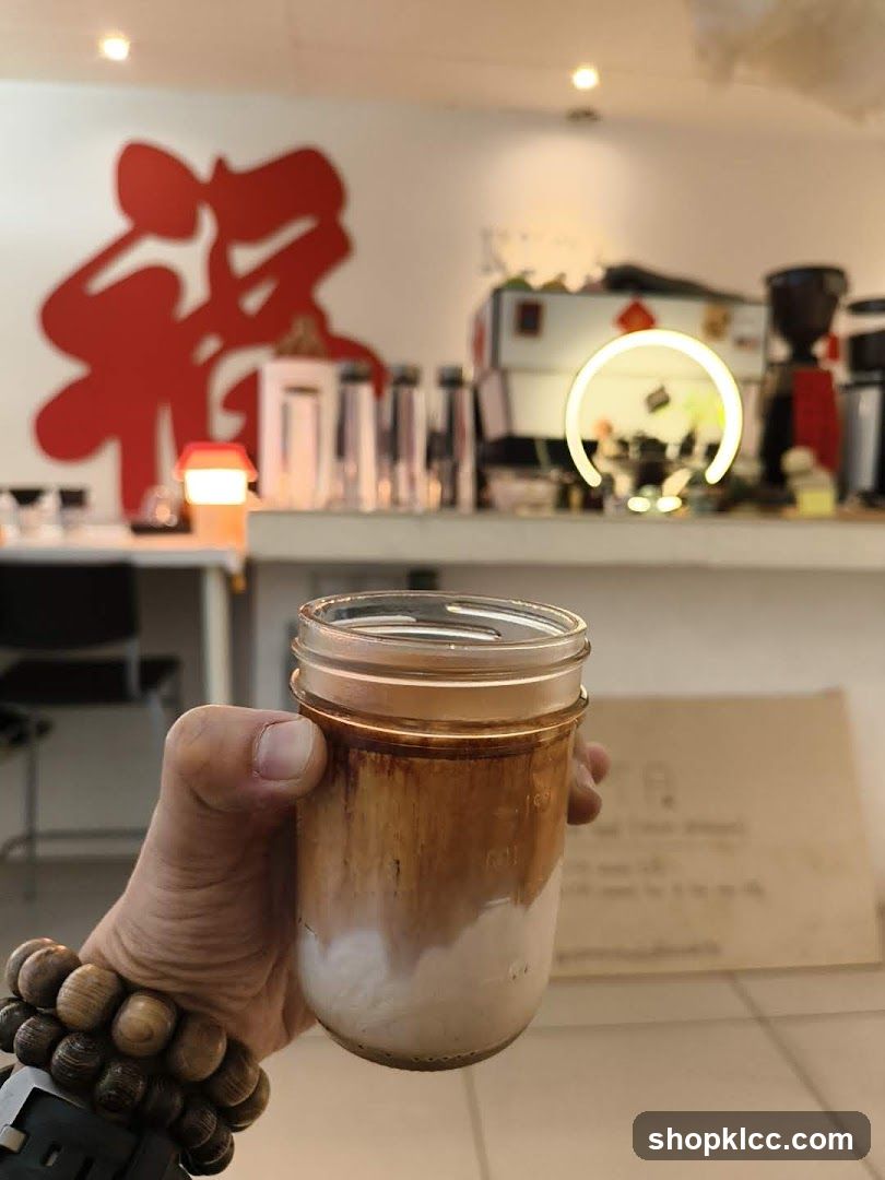 Hand holding a layered coffee drink