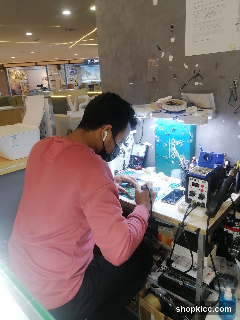 Electronics repair technician working at a desk