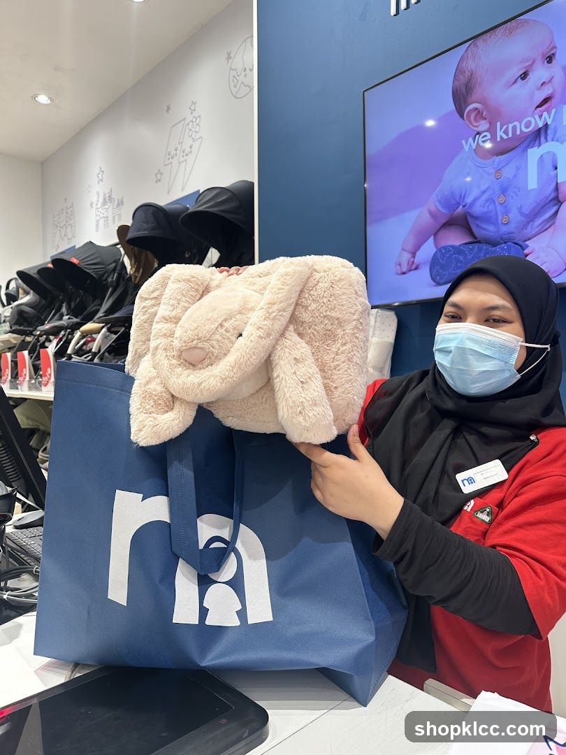 Employee holding a plush toy and shopping bag
