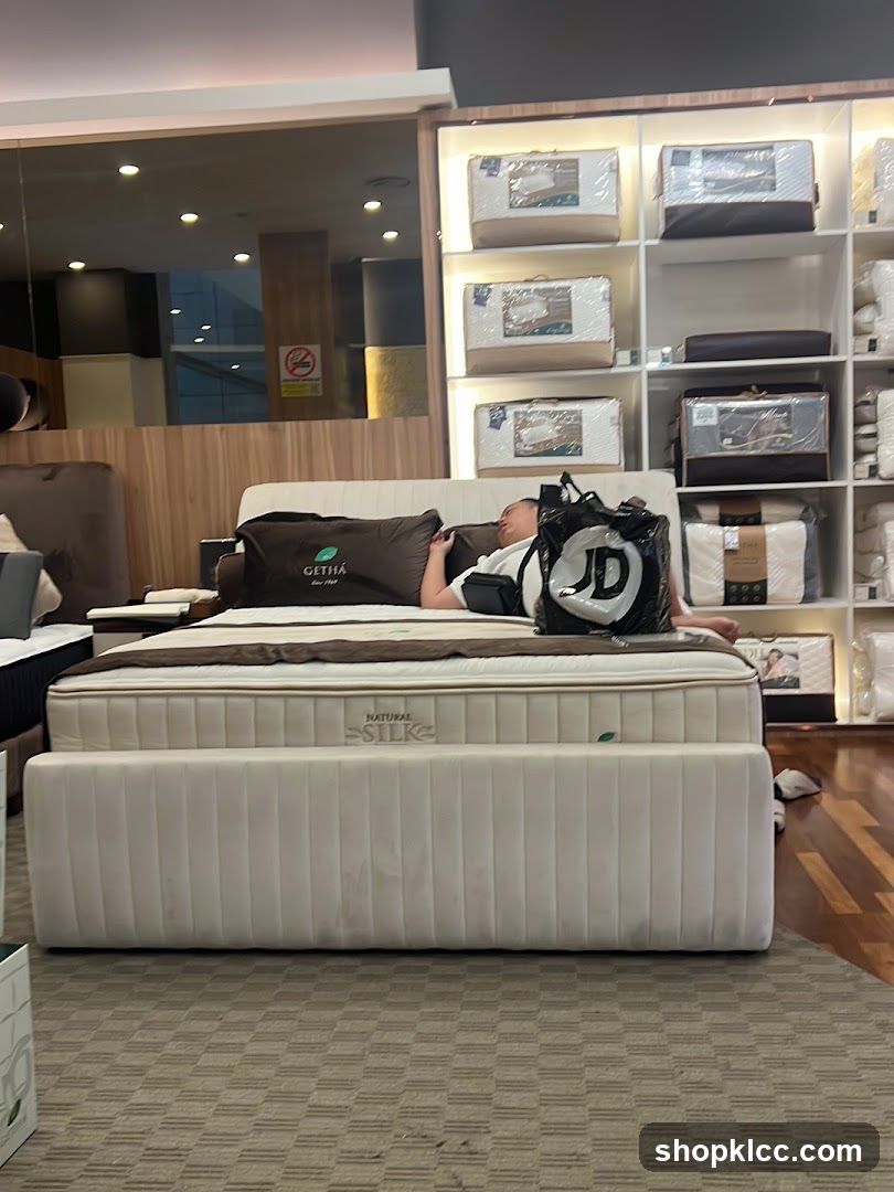 Man resting on a bed in a mattress store