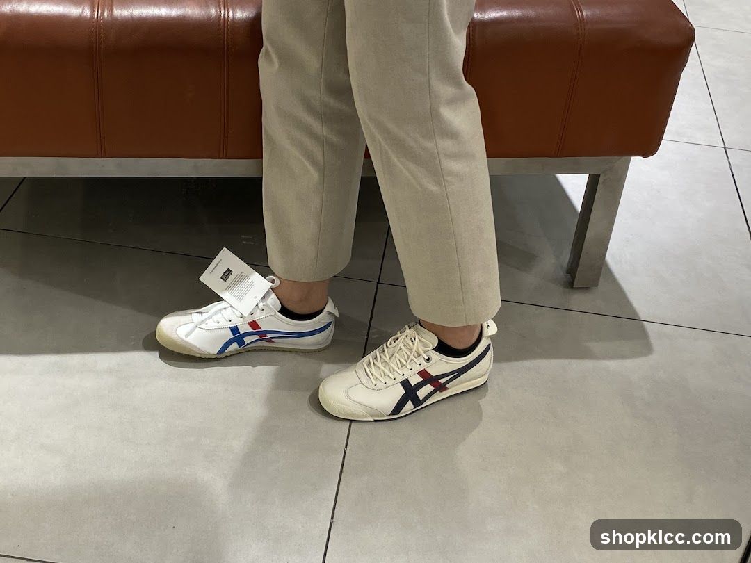 Person wearing white sneakers with blue and red stripes
