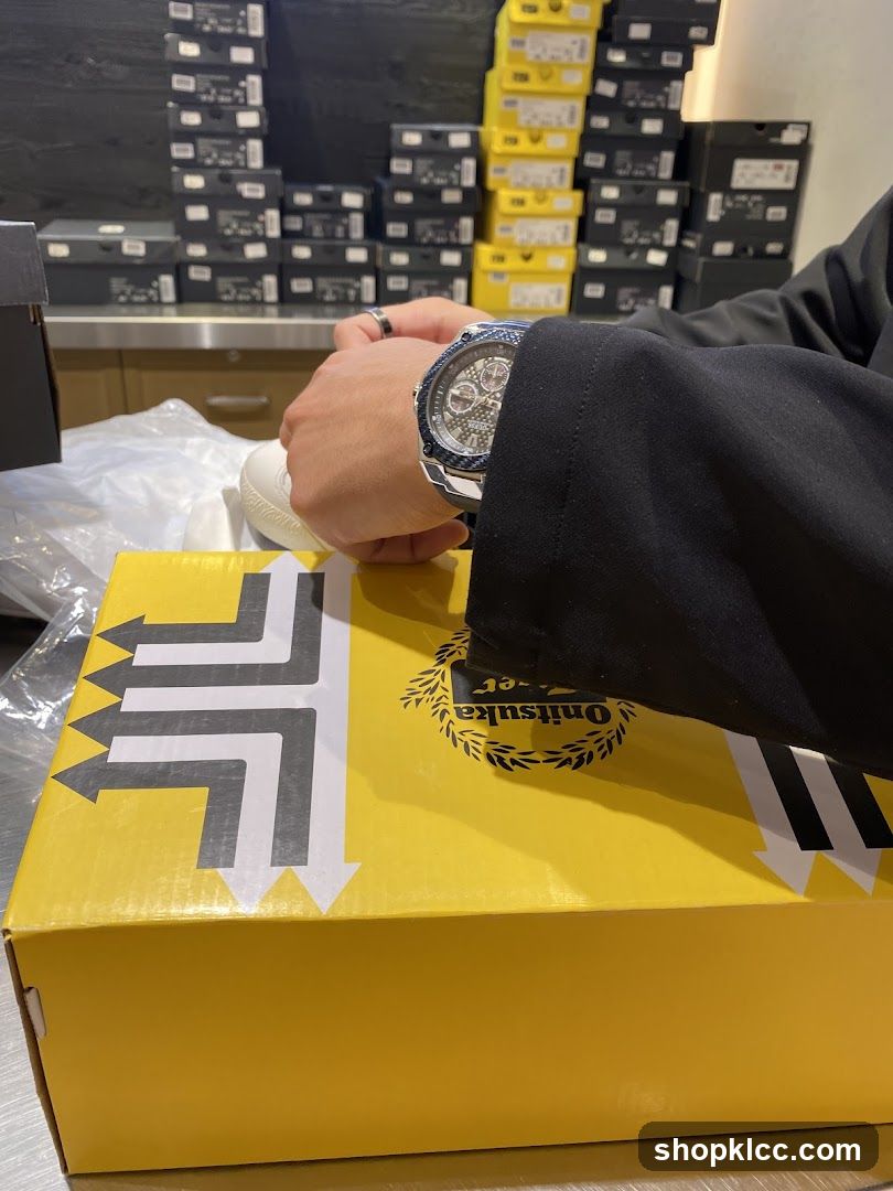Person wearing a watch and holding a shoe box