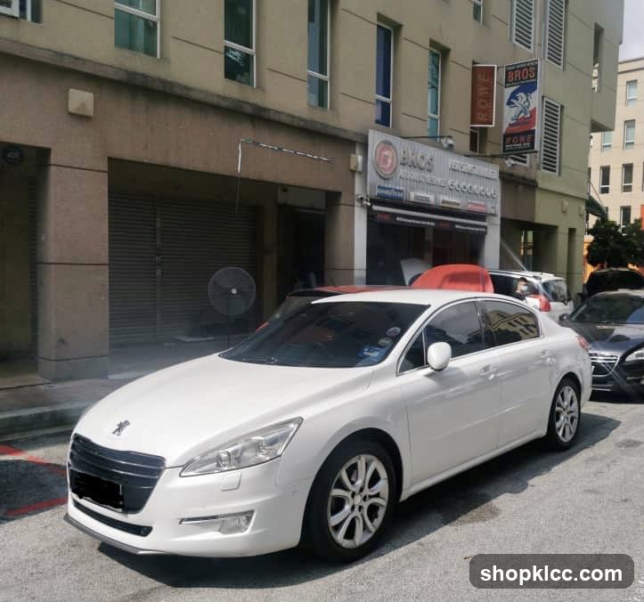White Peugeot parked in front of building