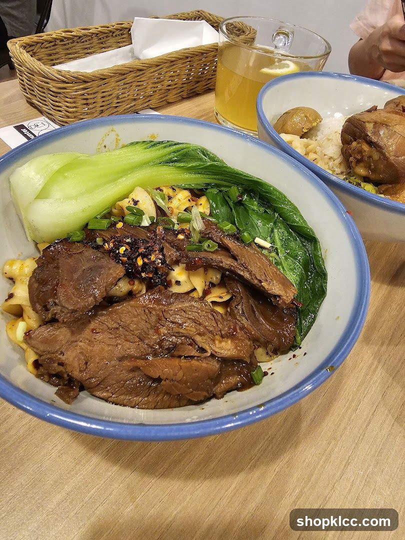 Beef noodle soup with bok choy and a side of braised meat and rice