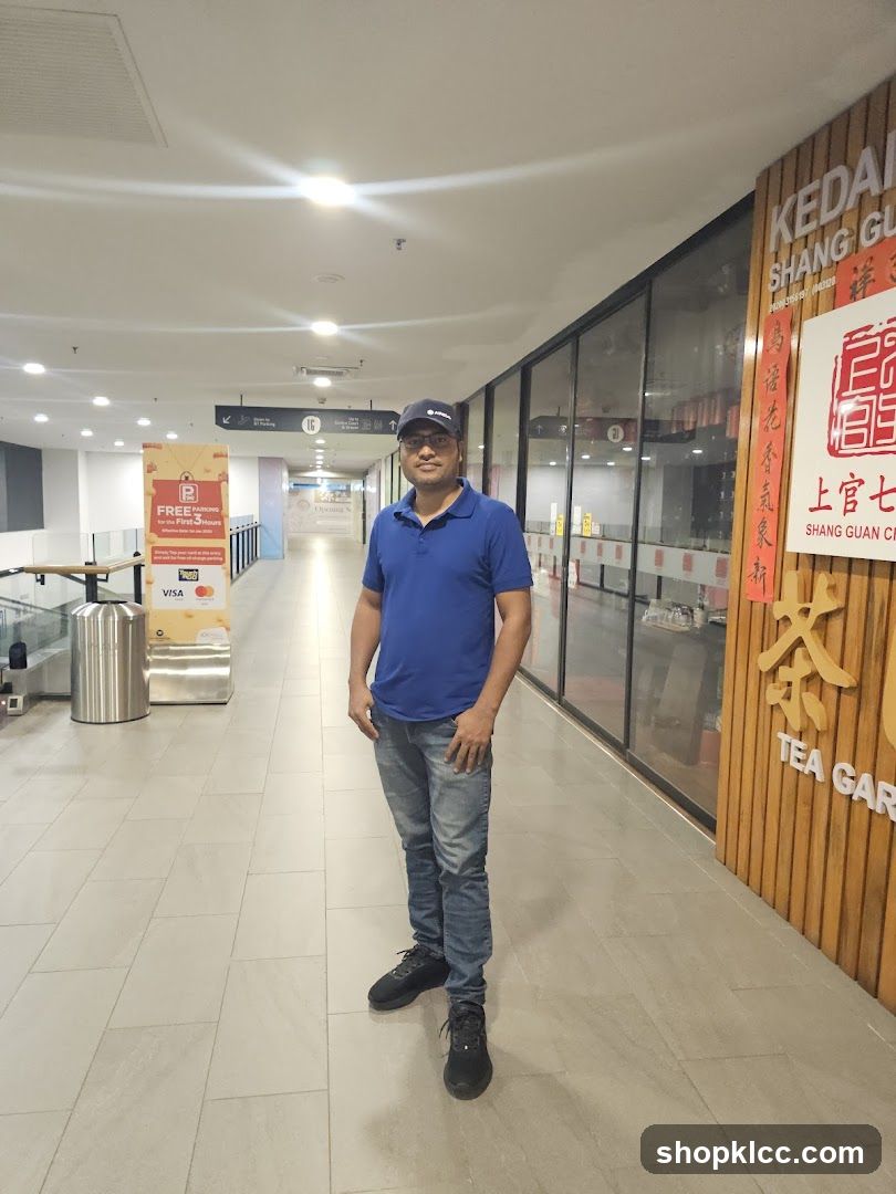 Man Standing in Mall Corridor