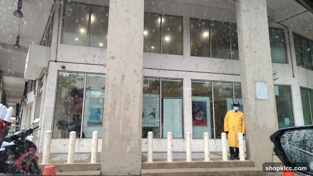 Person in yellow coat outside building
