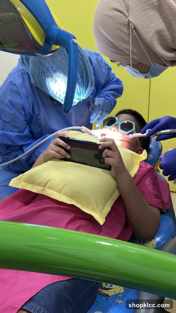 Child playing on phone during dental appointment