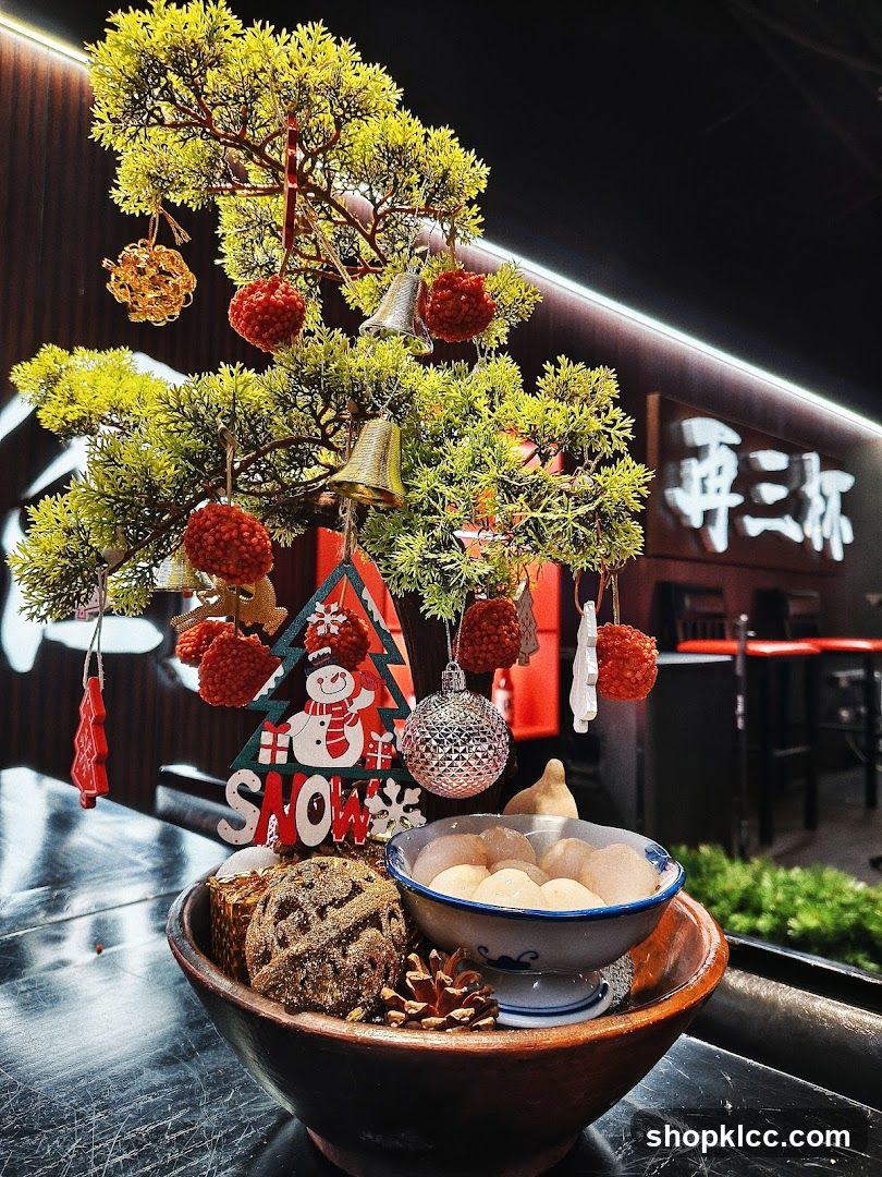 Christmas-themed table display with bonsai tree and snacks