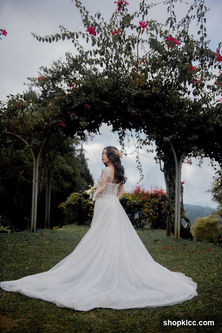 Bride in White Gown Under Flower Arch
