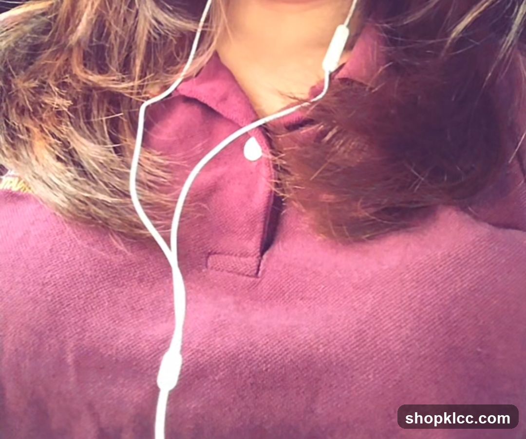 Person wearing maroon polo shirt with white earphones