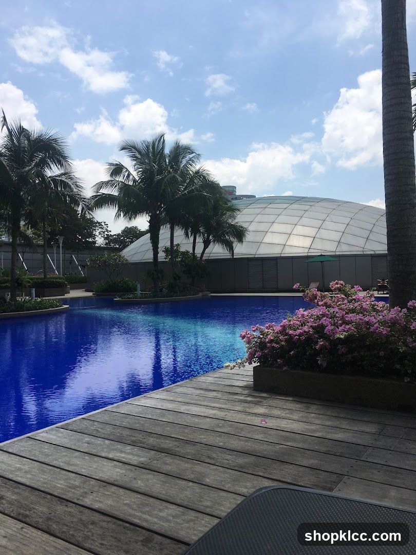 Poolside View with Palm Trees and Flowering Bushes