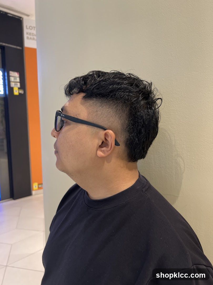 Side profile of a man with styled hair and sunglasses
