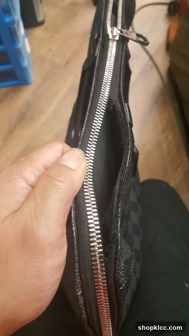 Close-up of a black checkered bag with a zipper