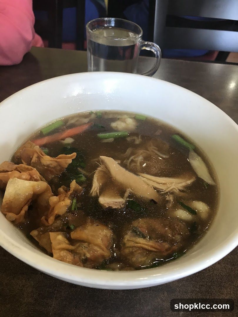 Bowl of noodle soup with wontons and chicken