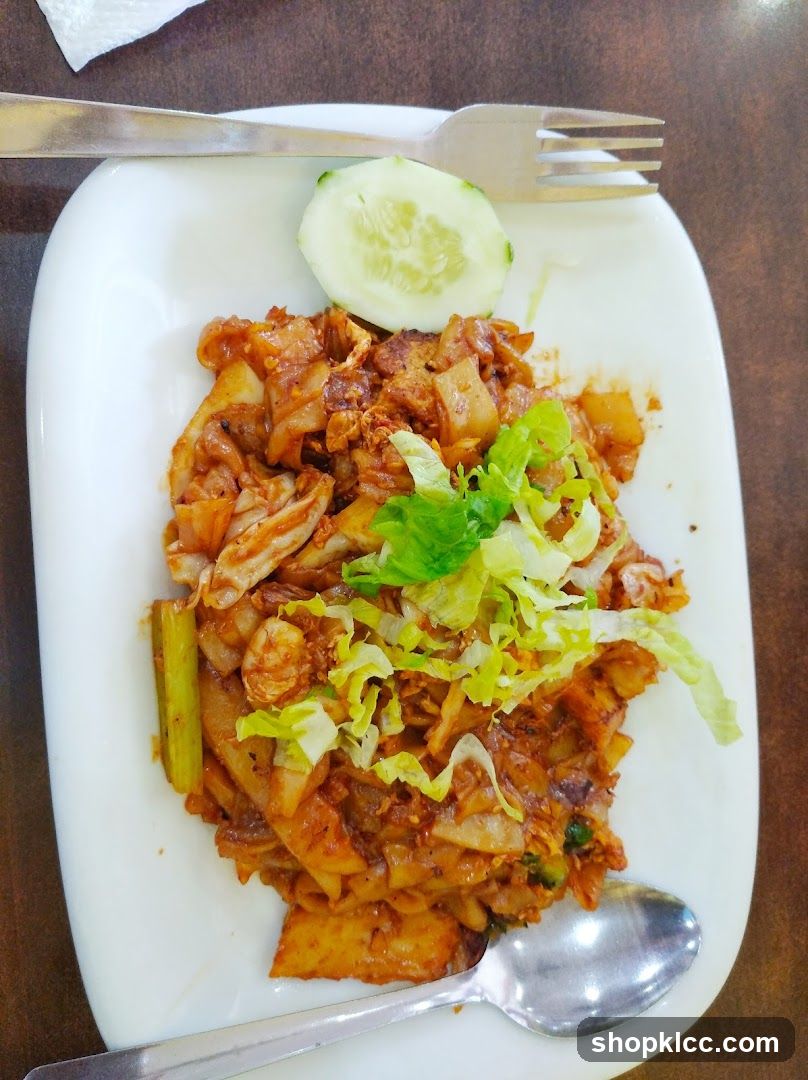 Stir-fried noodles with shredded lettuce and cucumber slice