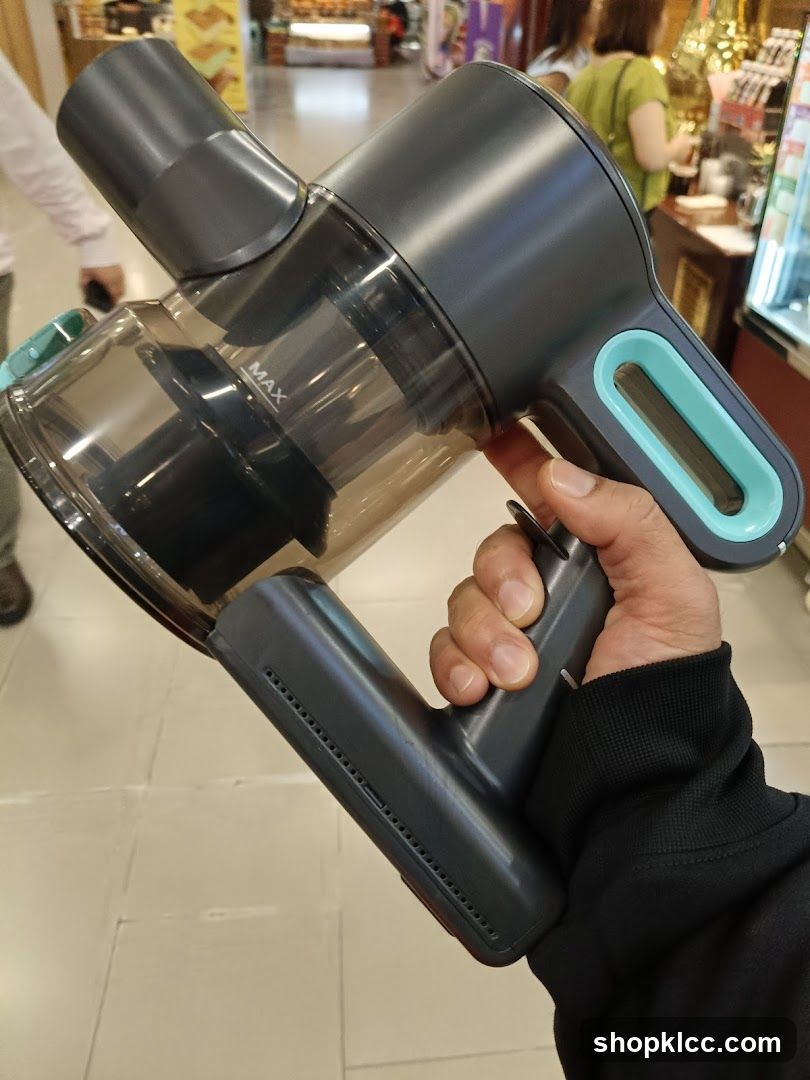 Hand holding a cordless vacuum cleaner