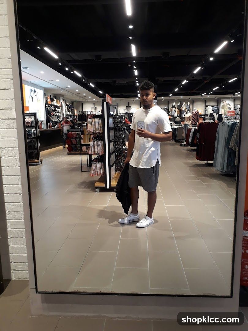 Man taking a mirror selfie in a clothing store