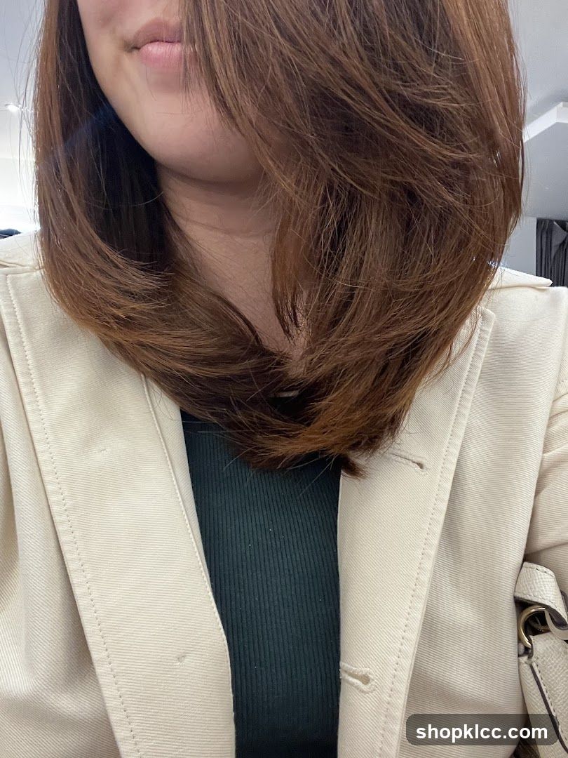 Woman with brown hair wearing a beige jacket