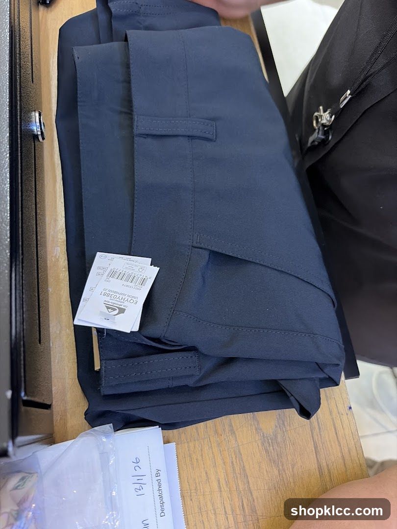 Folded dark blue trousers with tags
