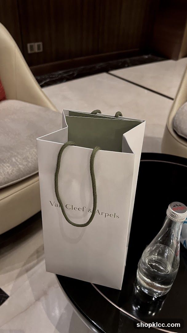 Van Cleef & Arpels shopping bag and Evian water bottle