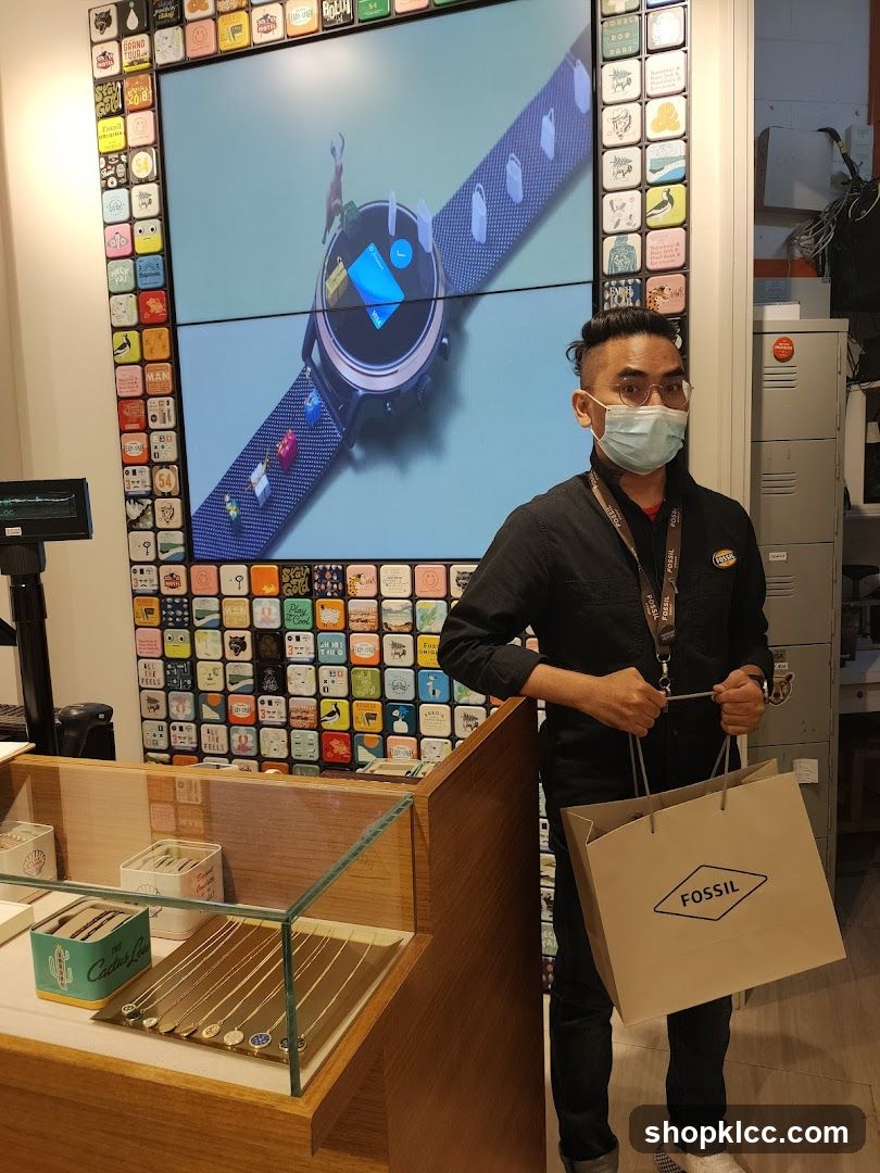 Man holding a Fossil shopping bag in a store