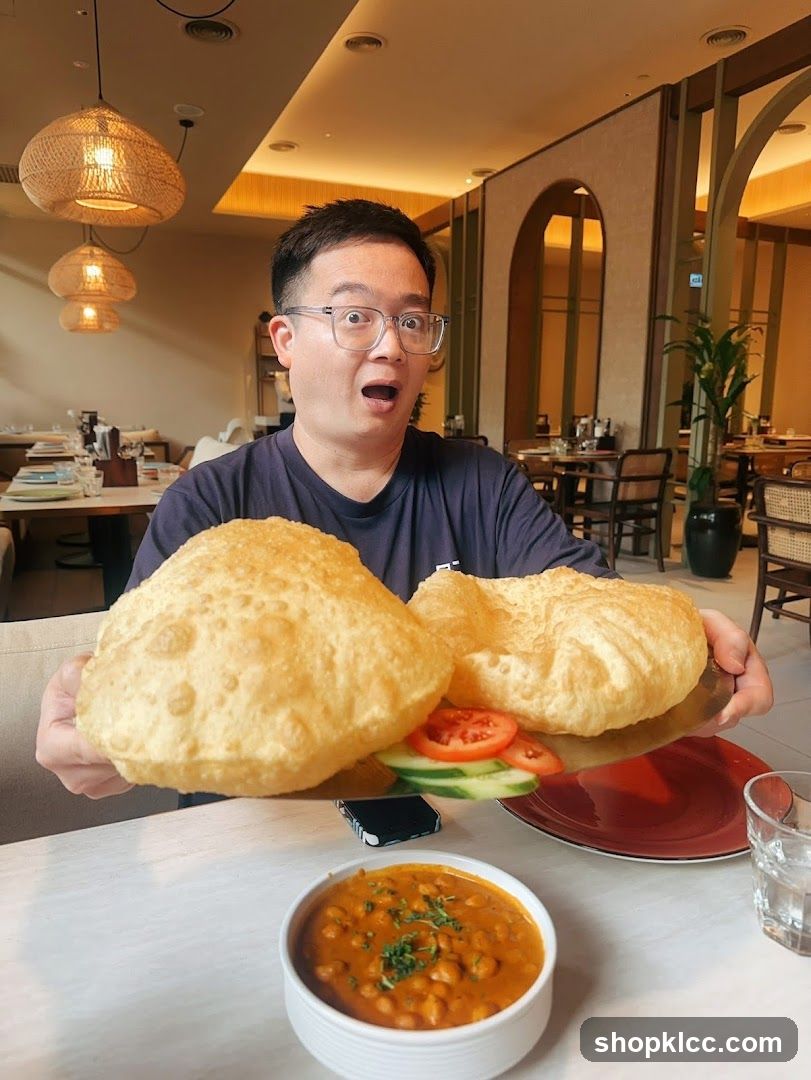 Man with large puri and chana masala
