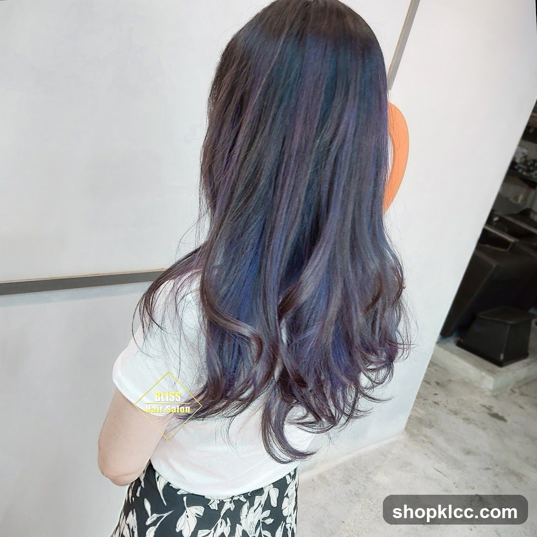 Woman with long, wavy, dark hair with blue and purple highlights