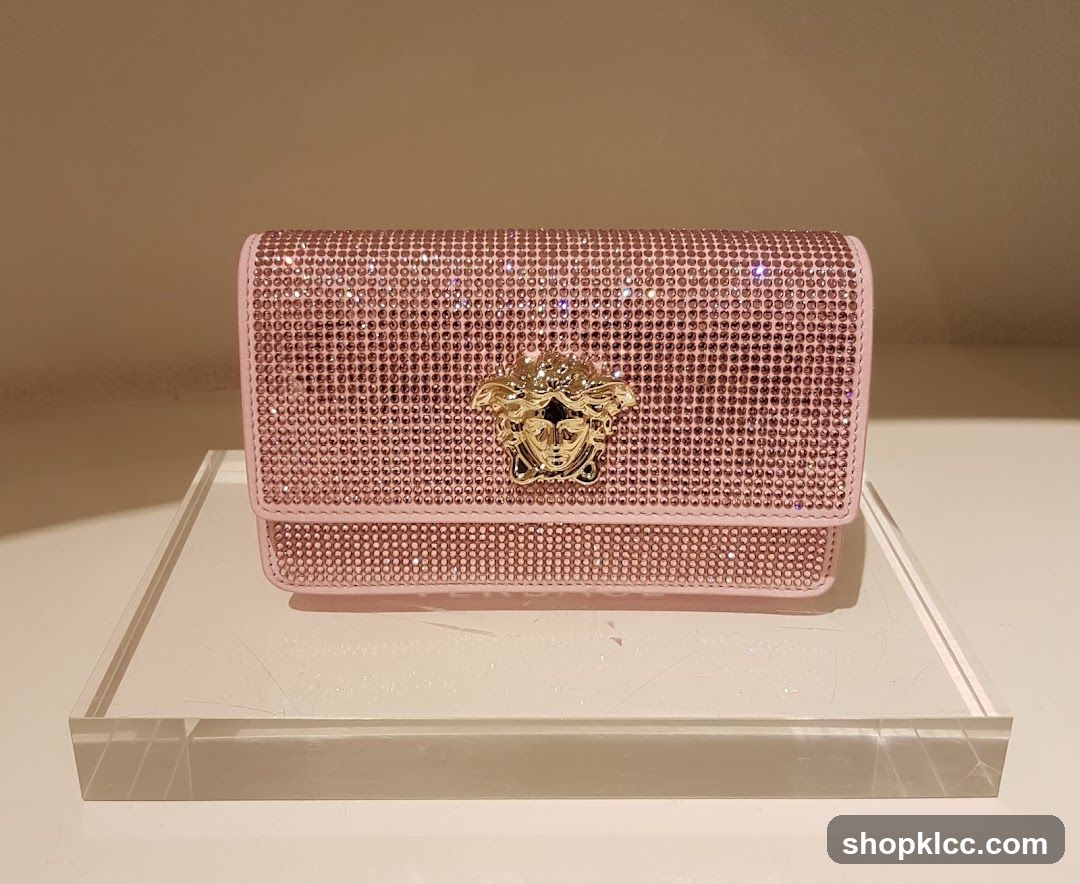 Pink jeweled clutch with Medusa head emblem