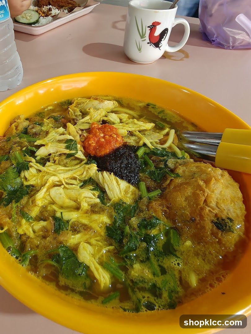 Bowl of Soup with Shredded Chicken and Condiments