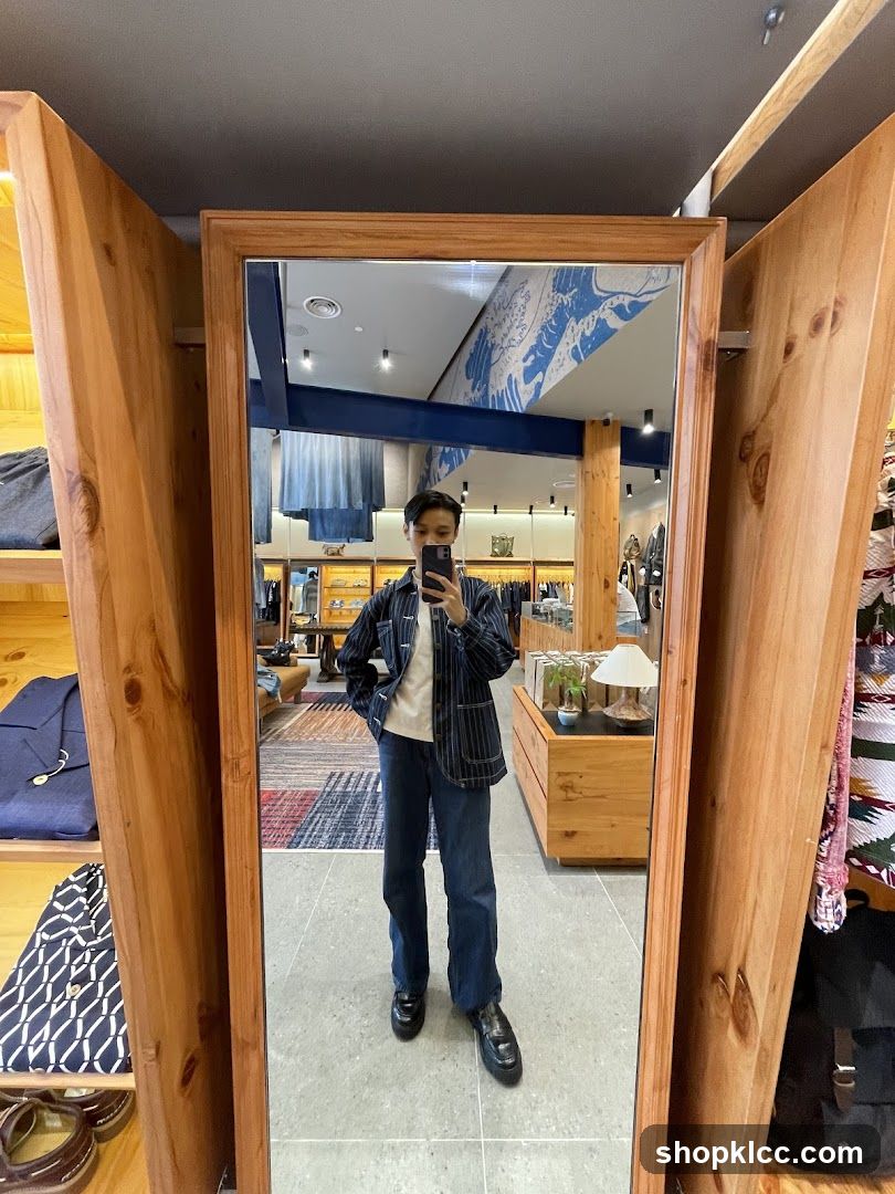 Man Taking Mirror Selfie in Clothing Store