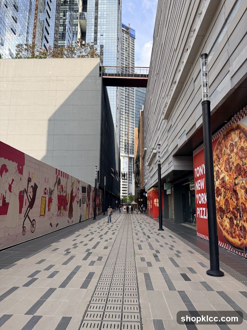 Outdoor walkway with modern buildings and pizza advertisement